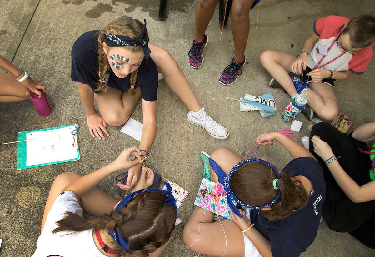 Anna Maddux of Pembroke watches as a fellow camper ties a friendship bracelet on her wrist Saturday, June 17. Arts and crafts were among the many activities available to campers as part of SCATS Olympics. (Photo by Brook Joyner)