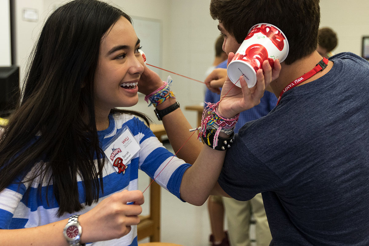 Sarah Pedersen of Barbourville and Grant Coorssen of Louisville play with cups during a Physics activity Monday, July 10. (Photo by Brook Joyner)