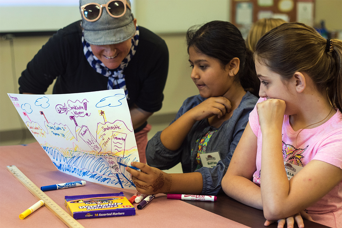 Aanyaa Arora (middle) shows her drawing to Art teacher Andee Rudolff in class Monday, July 10. (Photo by Brook Joyner