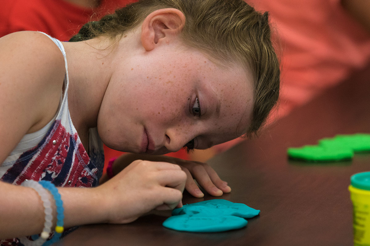 Avery Lewis plays with Play-Doh for an ice breaker activity in Science class Monday, July 10. Each student formed the clay into an object that meant something to them and then shared with the class. (Photo by Brook Joyner)