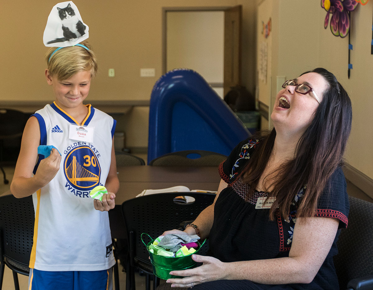Math teacher Allison Bemiss laughs as Owen Brown pulls mismatched socks out of the bucket in class Monday, July 10. Students learned about probability by seeing if they could randomly pick out two socks of the same color and pattern. (Photo by Brook Joyner)