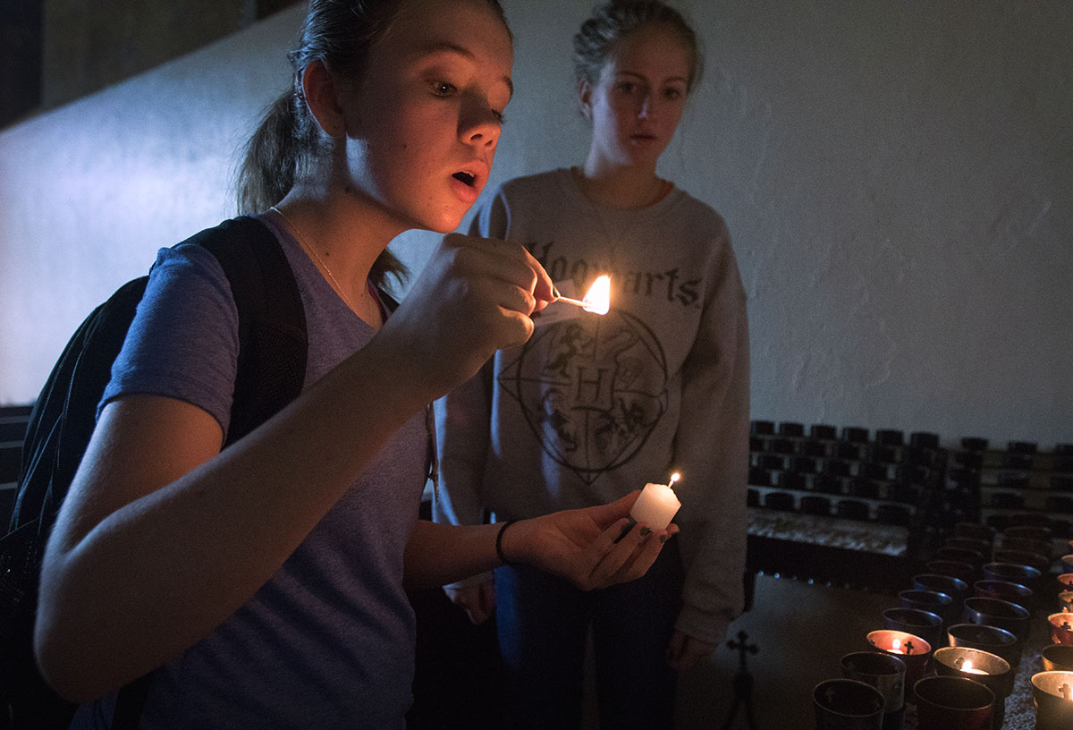 Alice Whitaker of Bowling Green lights a candle at the altar of Monte Cassino Shrine during a Humanities field trip to St. Meinrad, Ind. Monday, July 3. (Photo by Brook Joyner)