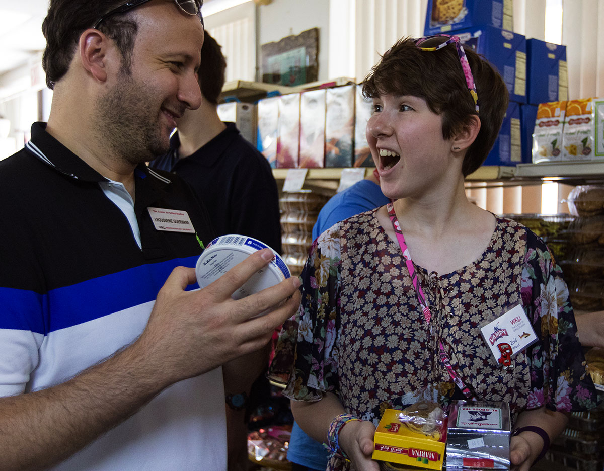 Arabic teacher Lhousseine Guerwane (left) and Zoe Ward of Frankfort wait in line to buy food at an international market in Nashville Tuesday, July 11. The class then had the opportunity to try new foods at an Arabic restaurant. (Photo by Brook Joyner)