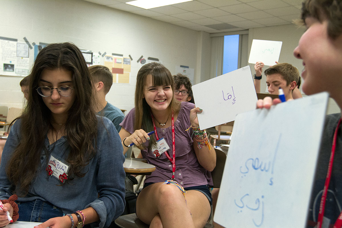 Emma Poole of Central City holds up the Arabic spelling of her name during Arabic Monday, July 3. (Photo by Sam Oldenburg)