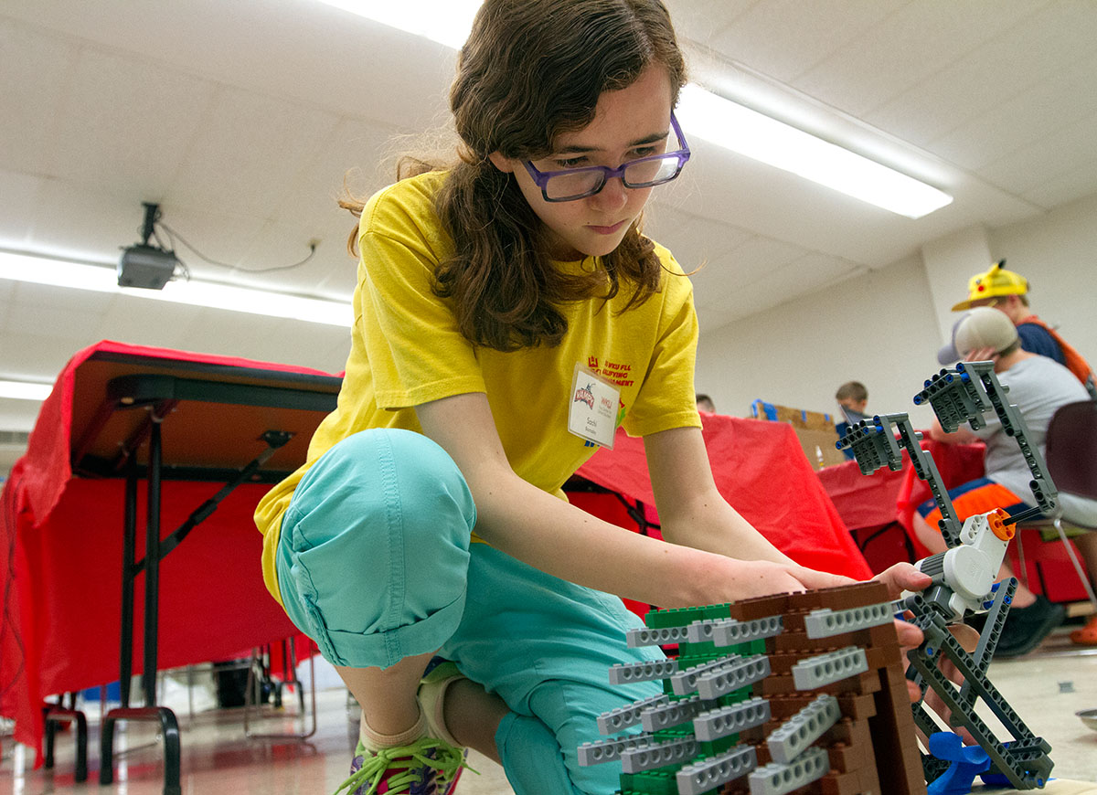Sachi Barnaby of Bowling Green sets up a Lego robot as part of her group's Rube Goldberg machine during STEAM Labs Monday, July 3. The robot was supposed to trigger the rolling of balls which would triggertoy cars running down a track which would pop a balloon. (Photo by Sam Oldenburg)