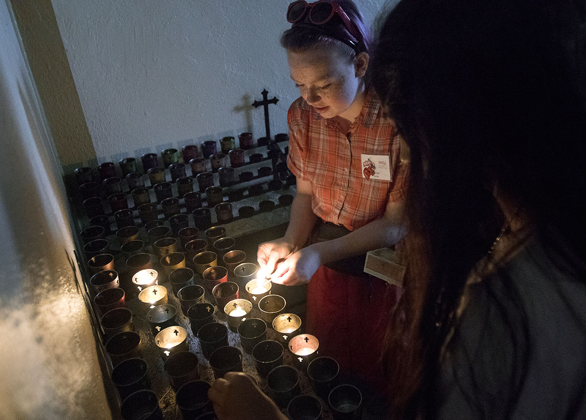 Evie Cooley of Louisville lights a candle inside the Monte Cassino Shrine during a Humanities field trip to St. Meinrad, Ind., Monday, July 3. (Photo by Brook Joyner)