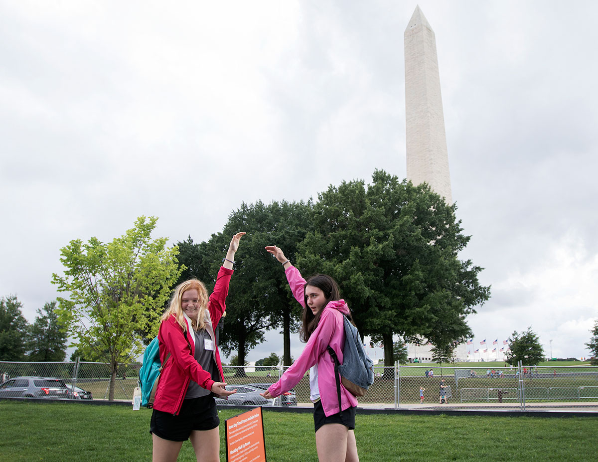 Sarah Ball (left) of Louisville and Maddie Holl of The Plains, Ohio pose for a picture with the Washington Monument during a field trip to Washington D.C. Thursday, July 6. The three classes on the trip then ended the day with a walking tour of some of the monuments around the National Mall. (Photo by Brook Joyner)