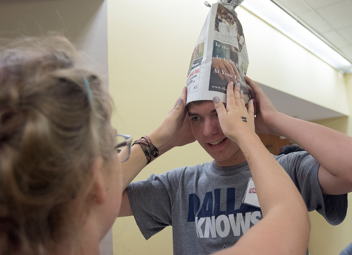 Ethan Tate of Louisville has a paper hat placed on his head by Jentry Bowles for paper theater Saturday, July 1. Ethan's group did their own rendition of Snow White and the Seven Dwarves for their skit. (Photo by Brook Joyner)