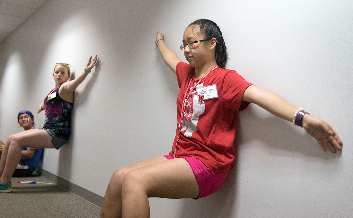 Lillian Shi of Clarksville, Tenn., competes in the endurance games portion of VAMPY Olympics Saturday, July 1. Campers who held a wall sit for the longest time won points for their team. (Photo by Brook Joyner)