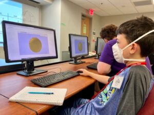 boy looking at computer showing geometry sphere